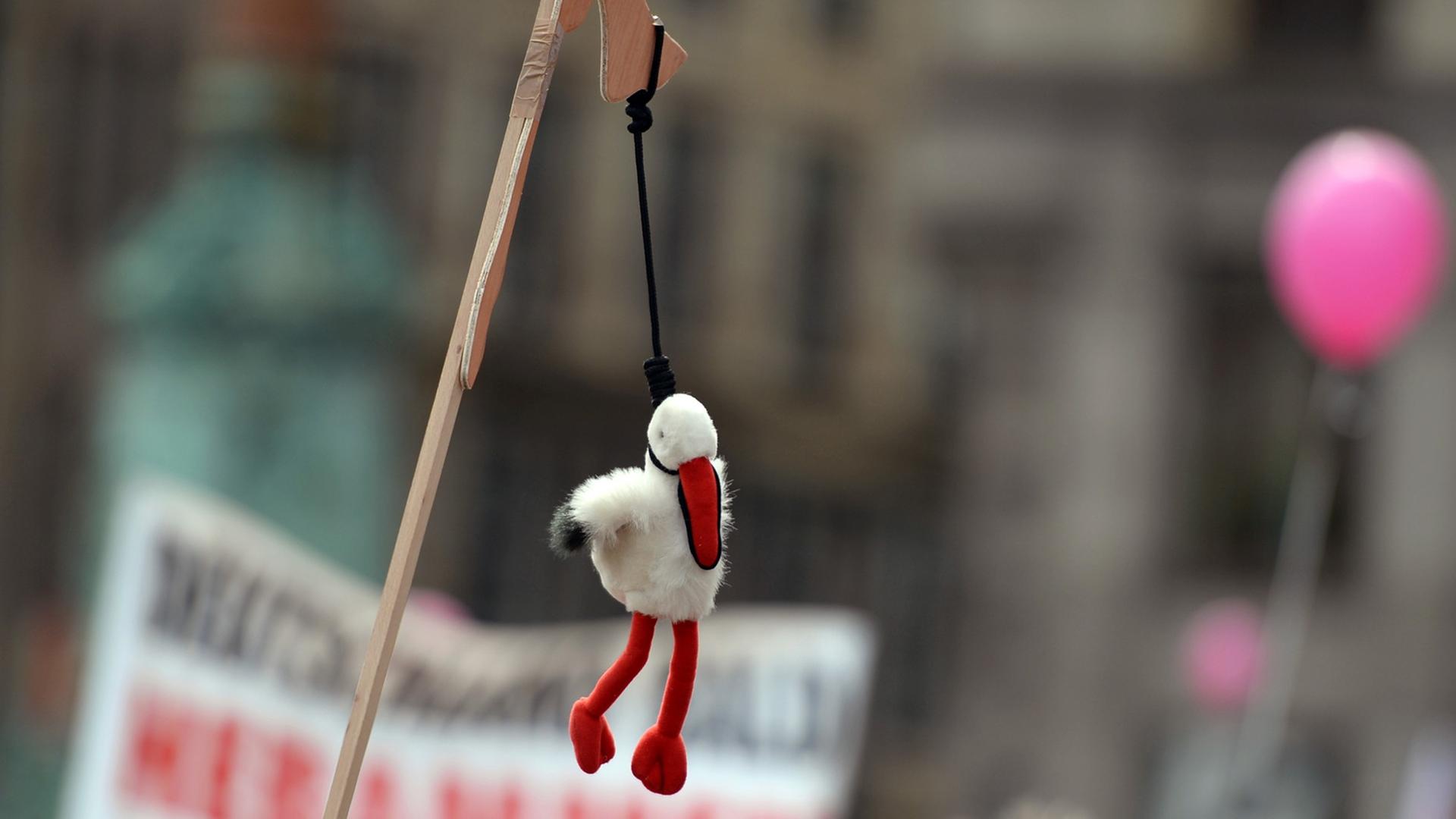 Ein Plüschstorch hängt am 26. Juni vor dem Rathaus in Hamburg auf einer Demonstration für die Rechte von Hebammen symbolisch am Galgen. Ein Plüschstorch hängt am 26. Juni vor dem Rathaus in Hamburg auf einer Demonstration für die Rechte von Hebammen symbolisch am Galgen.