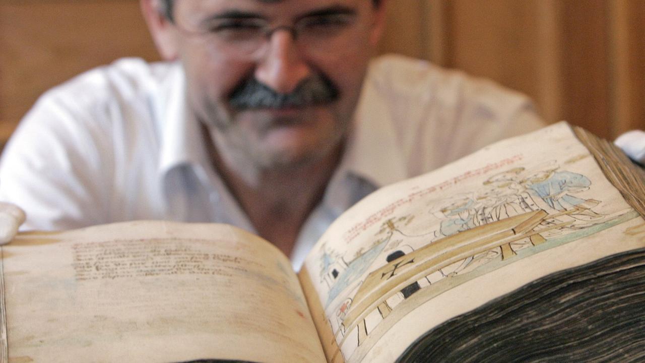 Den "Parzival" von Wolfram von Eschenbach zeigt Werner Hoffmann von der Universitätsbibliothek Leipzig während einer Präsentation mittelalterlicher Handschriften am Dienstag (12.08.2008) in Leipzig. Der Gralsroman entstand zu Beginn des 13. Jahrhunderts und ist in dieser handschriftlichen Fassung aus der Mitte des 15. Jahrhunderts 550 Seiten stark. Die Handschrift wurde wie weitere Stücke aus der kurfürstlichen, später königlich-sächsischen Bibliothek im Rahmen eines Forschungsprojektes in Leipzig digitalisiert und wissenschaftlich ausgewertet. Den "Parzival" von Wolfram von Eschenbach zeigt Werner Hoffmann von der Universitätsbibliothek Leipzig während einer Präsentation mittelalterlicher Handschriften am Dienstag (12.08.2008) in Leipzig. Der Gralsroman entstand zu Beginn des 13. Jahrhunderts und ist in dieser handschriftlichen Fassung aus der Mitte des 15. Jahrhunderts 550 Seiten stark. Die Handschrift wurde wie weitere Stücke aus der kurfürstlichen, später königlich-sächsischen Bibliothek im Rahmen eines Forschungsprojektes in Leipzig digitalisiert und wissenschaftlich ausgewertet.