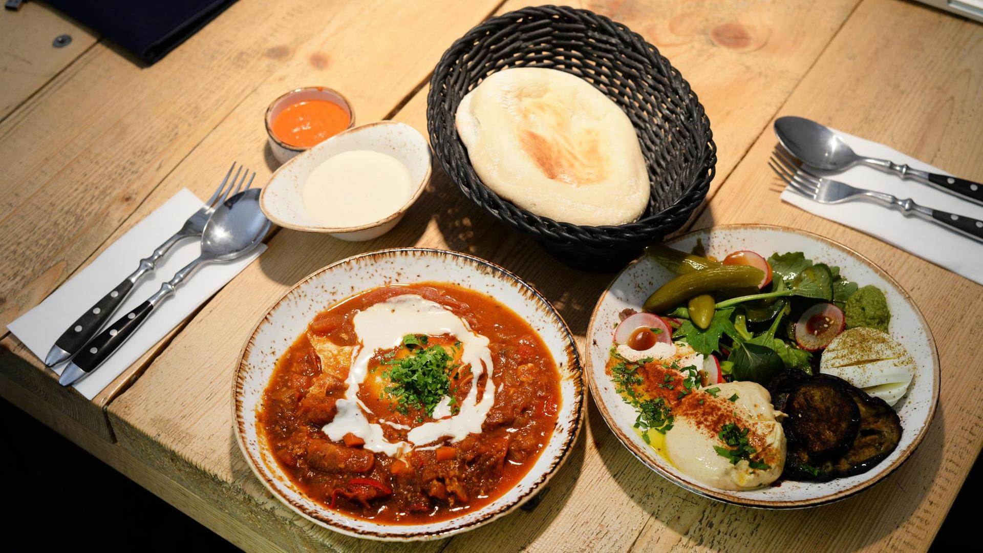 Traditionelles israelisches Eiergericht Shakshuka: Das Gericht wird aus pochierten Eiern in einer Sauce aus Tomaten, Paprika, Chilischoten und Zwiebeln zubereitet. Traditionelles israelisches Eiergericht Shakshuka: Das Gericht wird aus pochierten Eiern in einer Sauce aus Tomaten, Paprika, Chilischoten und Zwiebeln zubereitet.
