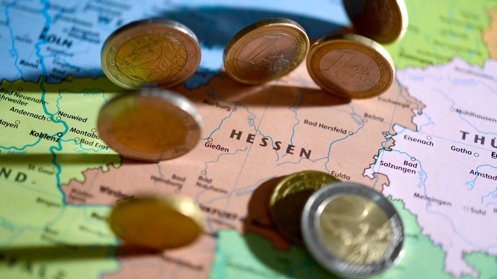 Euro-Münzen liegen auf einer Landkarte, zu sehen sind das Bundesland Hessen und die benachbarten Bundesländer. Euro-Münzen liegen auf einer Landkarte, zu sehen sind das Bundesland Hessen und die benachbarten Bundesländer.