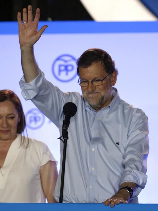 Mariano Rajoy winkt auf einer Bühne seinen Anhängern zu.