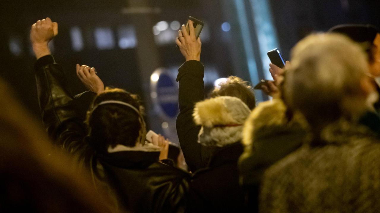 Von hinten zu sehende Demonstranten halten bei einem Protest gegen das neue Sicherheitsgesetz in Frankreich Handys in die Höhe, weil das Gesetz das Filmen von Polizeieinsätzen in Zukunft verbieten soll.
