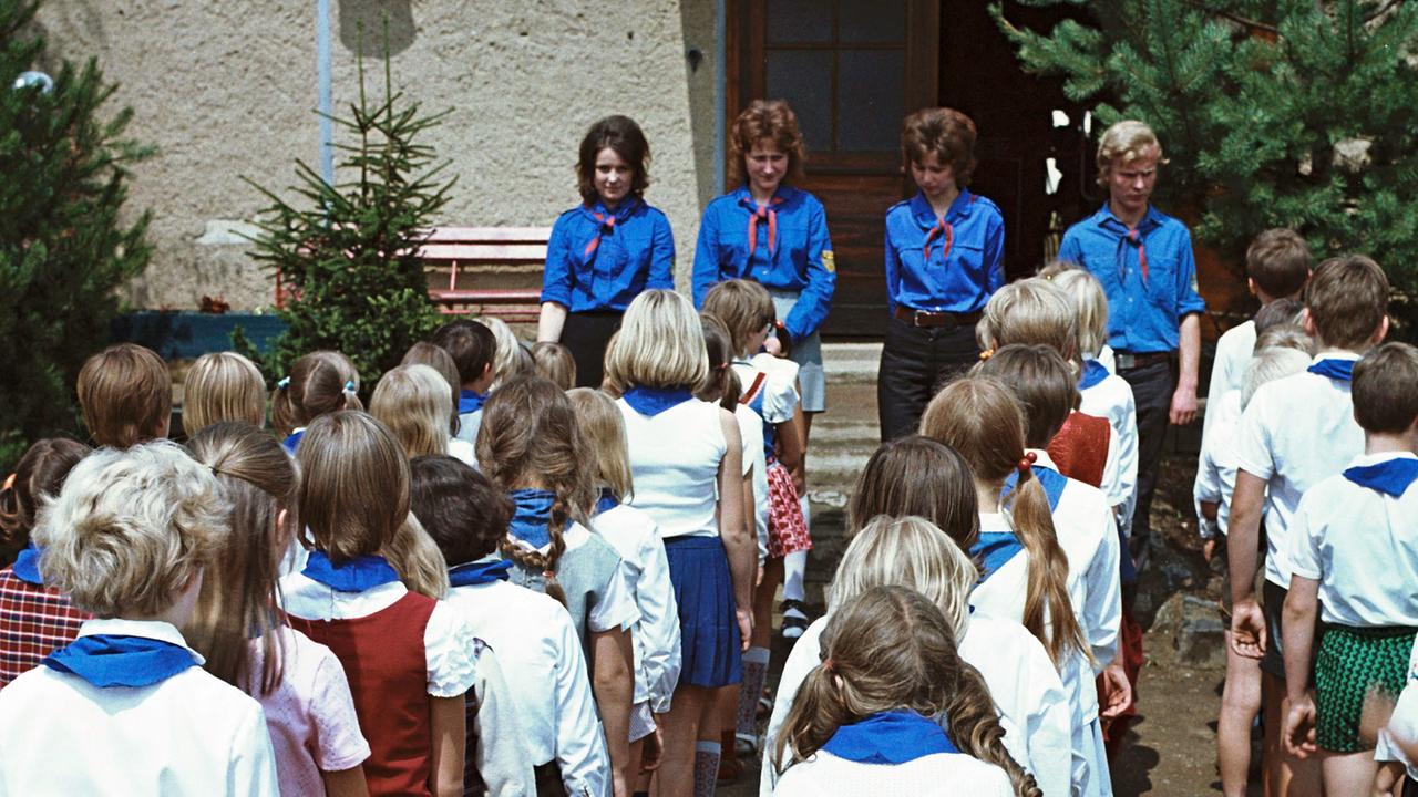 Kinder in Pionierkleidung mit blauen Halstüchern und ihre Betreuer von der FDJ bei einem Appell im Ferienheim des VEB Zemag Zeitz in Schneeberg, in dem die Schüler im Sommer 1972 einen Teil ihrer Schulferien verbringen Kinder in Pionierkleidung mit blauen Halstüchern und ihre Betreuer von der FDJ bei einem Appell im Ferienheim des VEB Zemag Zeitz in Schneeberg, in dem die Schüler im Sommer 1972 einen Teil ihrer Schulferien verbringen