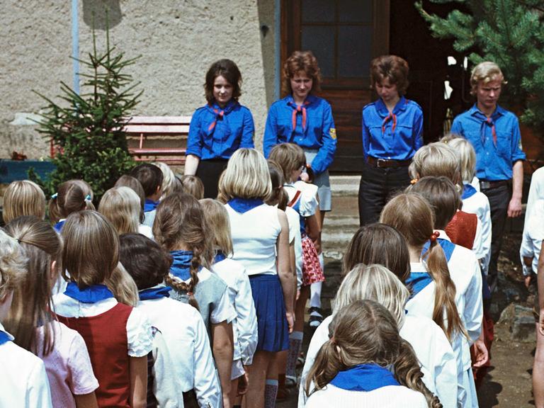 Kinder in Pionierkleidung mit blauen Halstüchern und ihre Betreuer von der FDJ bei einem Appell im Ferienheim des VEB Zemag Zeitz in Schneeberg, in dem die Schüler im Sommer 1972 einen Teil ihrer Schulferien verbringen