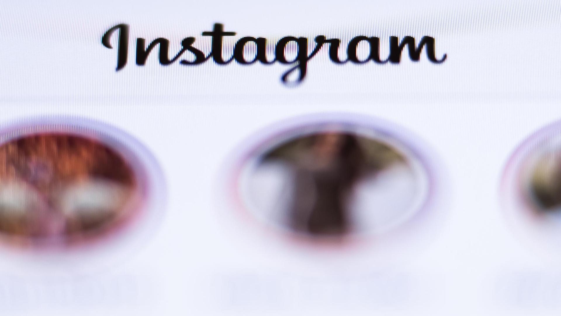 Der Schriftzug «Instagram» ist über der geöffneten App des Fotonetzwerks auf einem Display eines Smartphones zu sehen. Der Schriftzug «Instagram» ist über der geöffneten App des Fotonetzwerks auf einem Display eines Smartphones zu sehen.