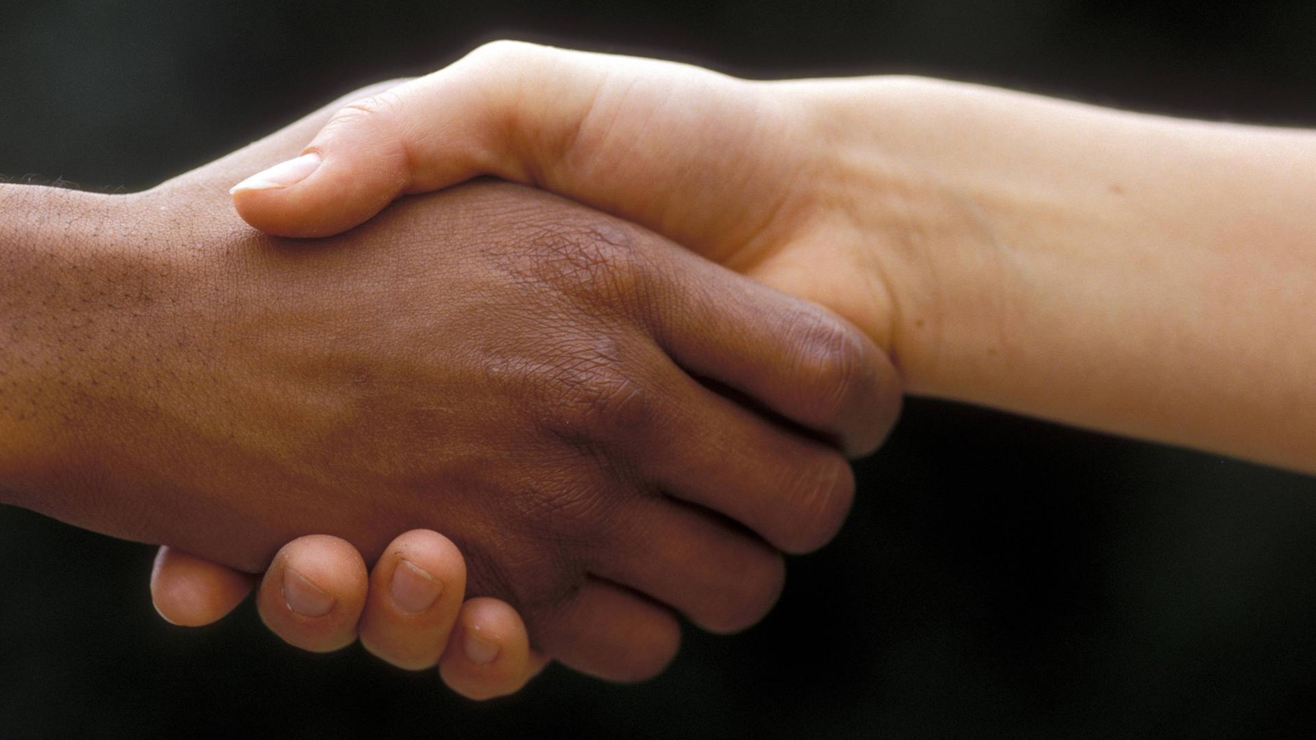 Menschen unterschiedlicher Hautfarbe geben sich die Hand. Menschen unterschiedlicher Hautfarbe geben sich die Hand.