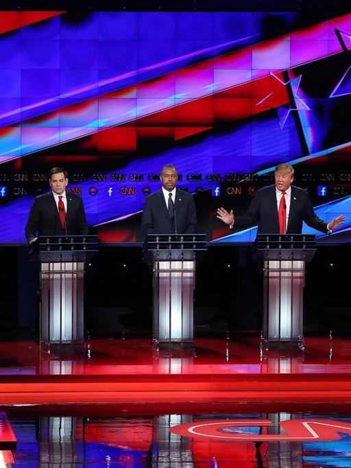 Zu sehen ist ein Fernsehstudio in Las Vegas und mehrere Kandidaten der US-Republikaner an Stehpulten.