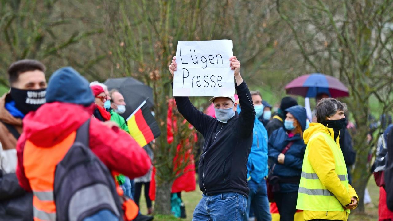 Eine "Querdenken"-Demonstration in Frankfurt am Main. Ein Demonstrant sein Schild mit der Aufschrift "Lügenpresse" hoch.