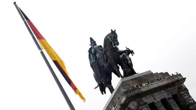 Reiterstandbild des Kaisers Wilhelm I. am Deutschen Eck in Koblenz. Daneben eine schlaff herabhängende Deutschlandfahne.