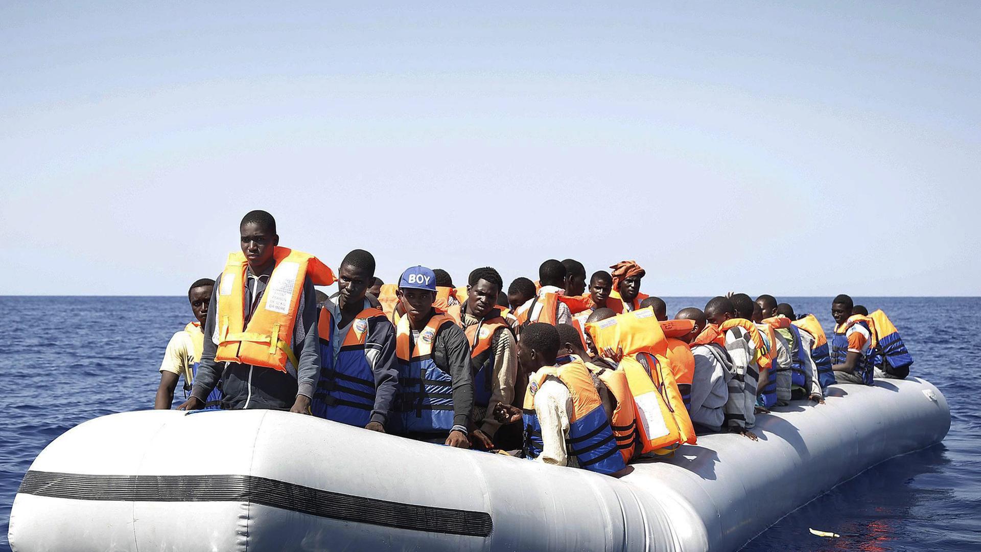 Ein Boot mit Dutzenden Flüchtlingen aus Afrika auf offener See. Ein Boot mit Dutzenden Flüchtlingen aus Afrika auf offener See.