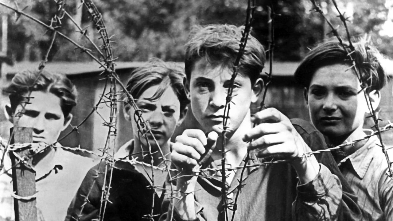 Junge Exodus-Flüchtlinge hinter Stacheldraht im Lager Pöppendorf am 10.09.1947. Die 4500 Flüchtlinge der Exodus-Schiffe "Ocean Vigour", "Empire Reval" und Runnymede Park" waren kurz zuvor im Hamburger Hafen eingetroffen. Sie wurden in stark bewachten Zügen nach Lübeck gebracht und von dort in das nahegelegene Lager Pöppendorf. Mehrere tausend Juden waren am 11. Juli auf der "Exodus 1947" und anderen Schiffen von Frankreich aus ins unter britischem Mandat stehende Gelobte Land aufgebrochen. Junge Exodus-Flüchtlinge hinter Stacheldraht im Lager Pöppendorf am 10.09.1947. Die 4500 Flüchtlinge der Exodus-Schiffe "Ocean Vigour", "Empire Reval" und Runnymede Park" waren kurz zuvor im Hamburger Hafen eingetroffen. Sie wurden in stark bewachten Zügen nach Lübeck gebracht und von dort in das nahegelegene Lager Pöppendorf. Mehrere tausend Juden waren am 11. Juli auf der "Exodus 1947" und anderen Schiffen von Frankreich aus ins unter britischem Mandat stehende Gelobte Land aufgebrochen.
