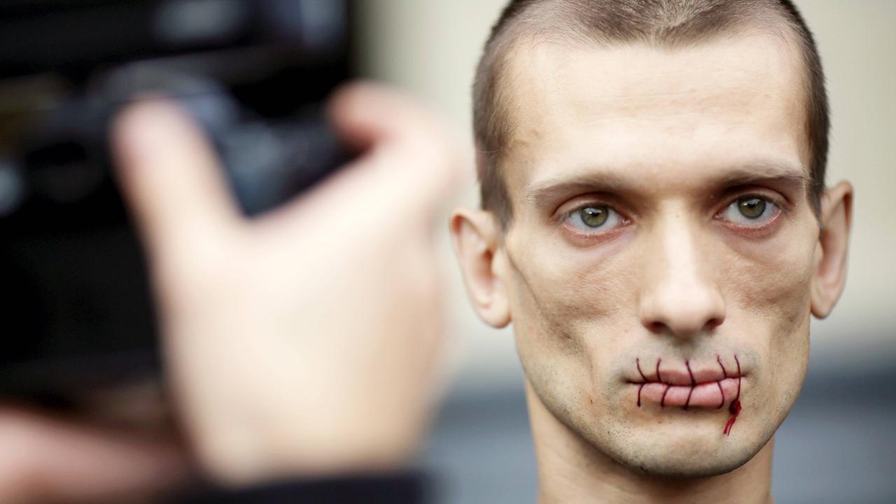 Der russische Aktionskünstler Pjotr Pawlenski protestiert mit zugenähtem Mund im Juli 2012 vor der St. Petersburger Kazan Kathedrale gegen die Verhaftung von Pussy Riot. Der russische Aktionskünstler Pjotr Pawlenski protestiert mit zugenähtem Mund im Juli 2012 vor der St. Petersburger Kazan Kathedrale gegen die Verhaftung von Pussy Riot.