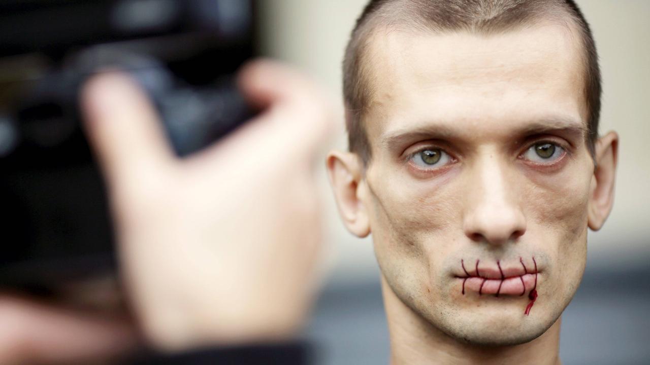 Der russische Aktionskünstler Pjotr Pawlenski protestiert mit zugenähtem Mund im Juli 2012 vor der St. Petersburger Kazan Kathedrale gegen die Verhaftung von Pussy Riot. Der russische Aktionskünstler Pjotr Pawlenski protestiert mit zugenähtem Mund im Juli 2012 vor der St. Petersburger Kazan Kathedrale gegen die Verhaftung von Pussy Riot.