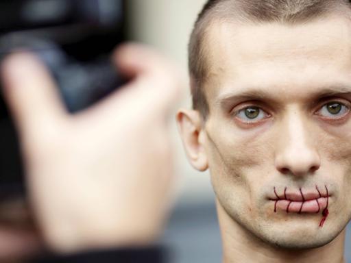 Der russische Aktionskünstler Pjotr Pawlenski protestiert mit zugenähtem Mund im Juli 2012 vor der St. Petersburger Kazan Kathedrale gegen die Verhaftung von Pussy Riot.