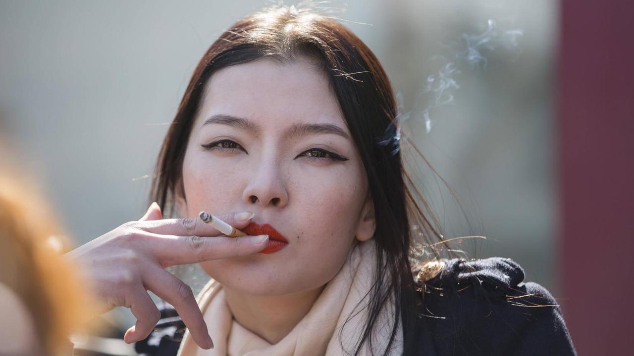 Das Bild zeigt eine rauchende Frau in Peking.