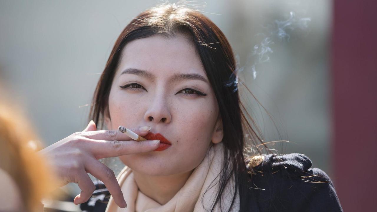 Das Bild zeigt eine rauchende Frau in Peking. Das Bild zeigt eine rauchende Frau in Peking.