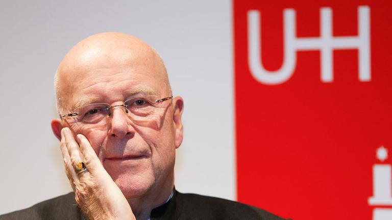 Der Präsident der Universität Hamburg, Dieter Lenzen, im Porträt. Er stützt eine Hand im Gesicht auf, im Hintergrund ist ein rotes Plakat zu sehen. Der Präsident der Universität Hamburg, Dieter Lenzen, im Porträt. Er stützt eine Hand im Gesicht auf, im Hintergrund ist ein rotes Plakat zu sehen.