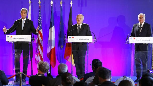 Die Außenminister der USA, Frankreichs und Deutschlands, Kerry, Ayrault und Steinmeier, stehen nebeneinander auf einem Podium hinter Rednerpulten und vor blauen Hintergrund.