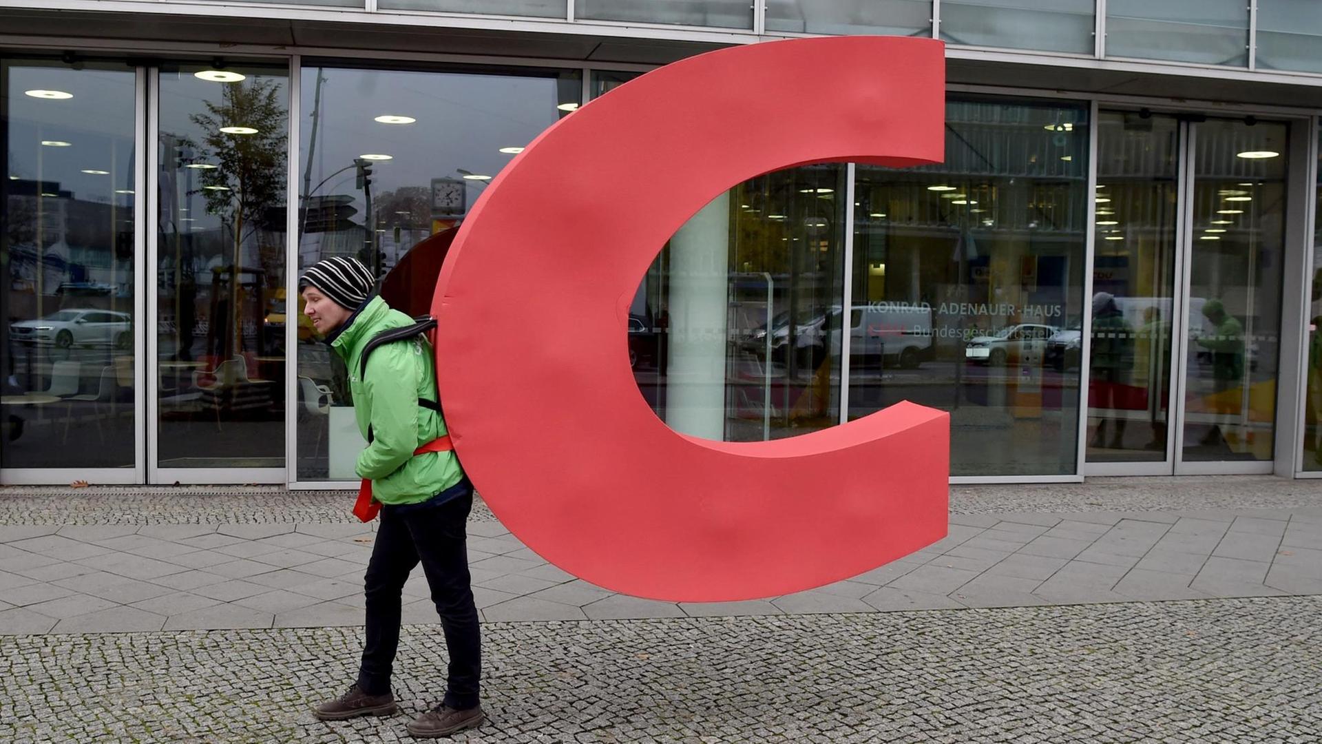 Ein Aktivist von Greenpeace trägt den Buchstaben C aus dem Parteiennamen CDU aus der CDU-Bundesgeschäftsstelle, dem Konrad-Adenauer-Haus. Ein Aktivist von Greenpeace trägt den Buchstaben C aus dem Parteiennamen CDU aus der CDU-Bundesgeschäftsstelle, dem Konrad-Adenauer-Haus.