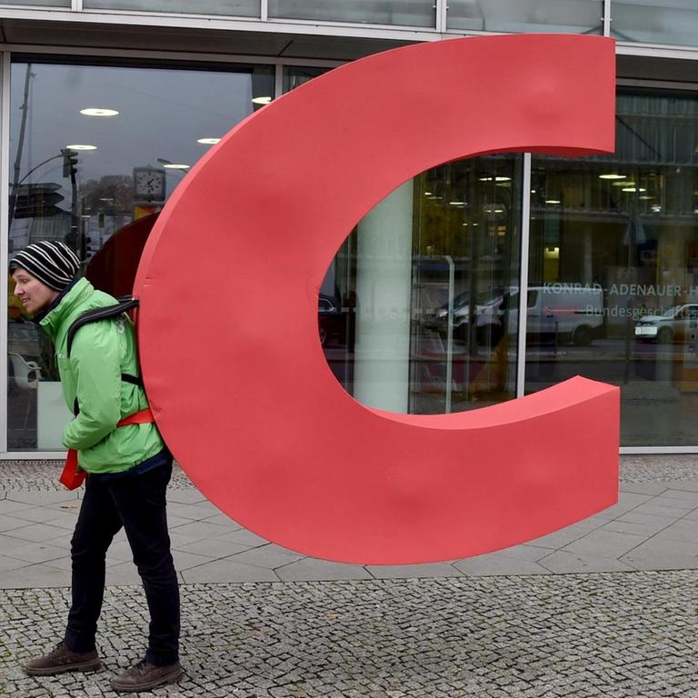 Ein Aktivist von Greenpeace trägt den Buchstaben C aus dem Parteiennamen CDU aus der CDU-Bundesgeschäftsstelle, dem Konrad-Adenauer-Haus.