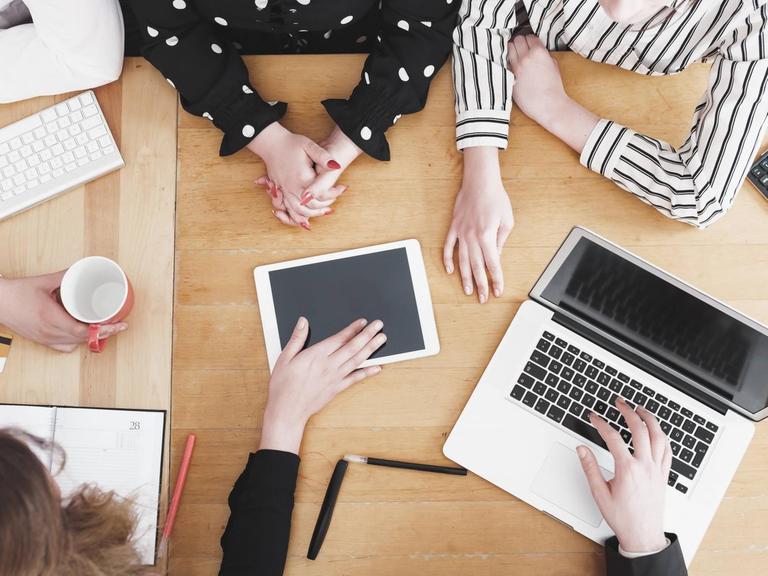 Junge Mitarbeiter im Startup diskutieren am Schreibtisch.