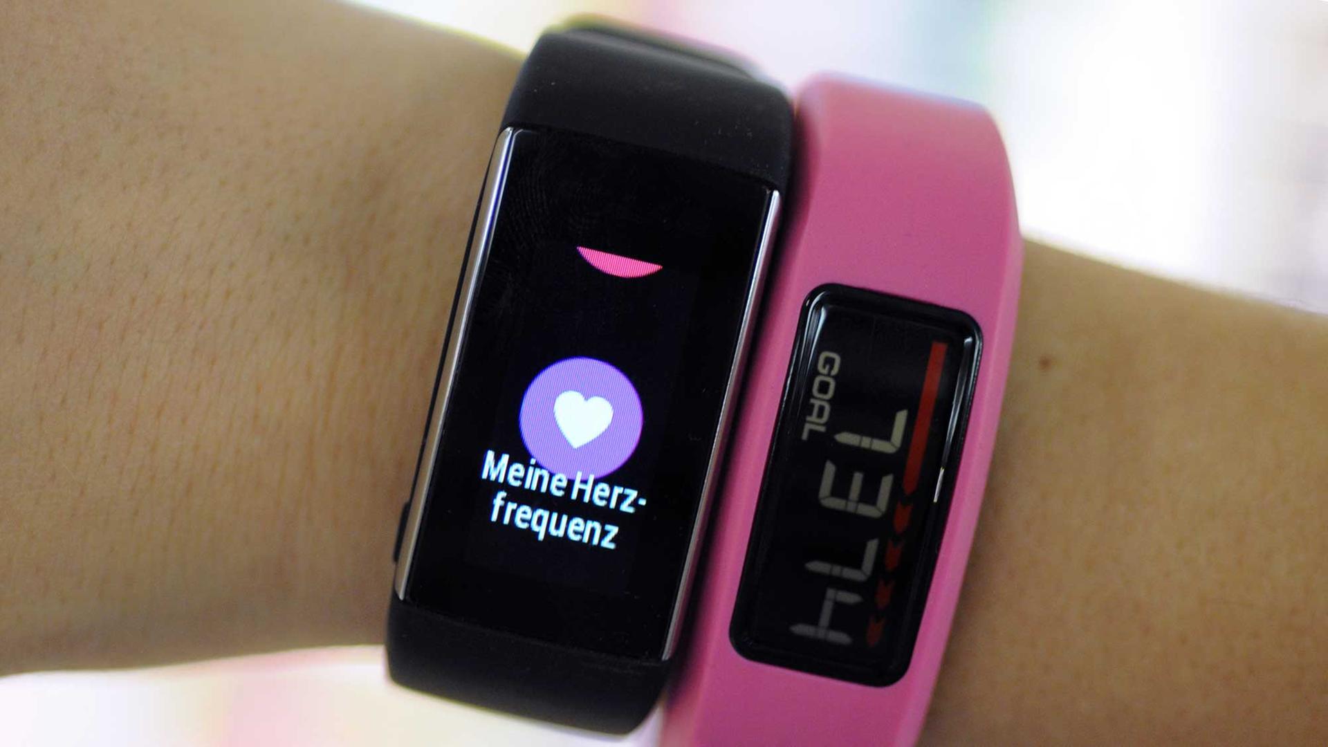 Eine Frau trägt Fitness-Armbänder, die zum Beispiel Herzfrequenz, Kalorienverbrauch oder Schrittzahl messen. Eine Frau trägt Fitness-Armbänder, die zum Beispiel Herzfrequenz, Kalorienverbrauch oder Schrittzahl messen.