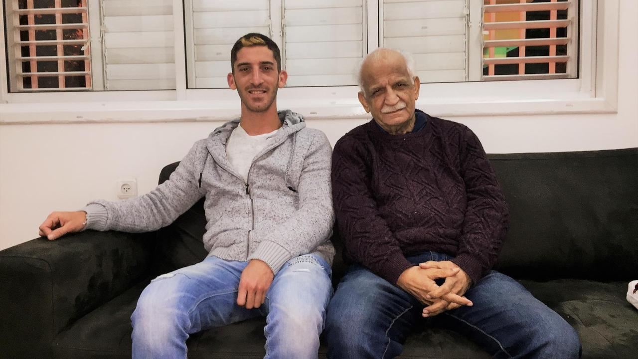 Der 74-jährige Historiker Benny Zedaka (rechts) und der 25-jährige Tom Zedaka (links) sitzen auf einem Sofa und schauen in die Kamera