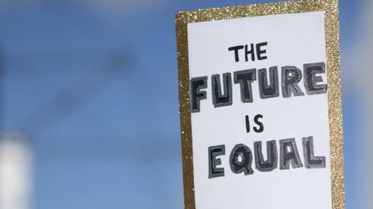 Das Foto zeigt eine Menge von Demonstrantinnen und ein Plakat mit der Aufschrift "Plakat The Future Is Equal" auf dem Internationalen Frauentag unter dem Motto Feiern Streiken Weiterkaempfen am 8. Maerz in Berlin.