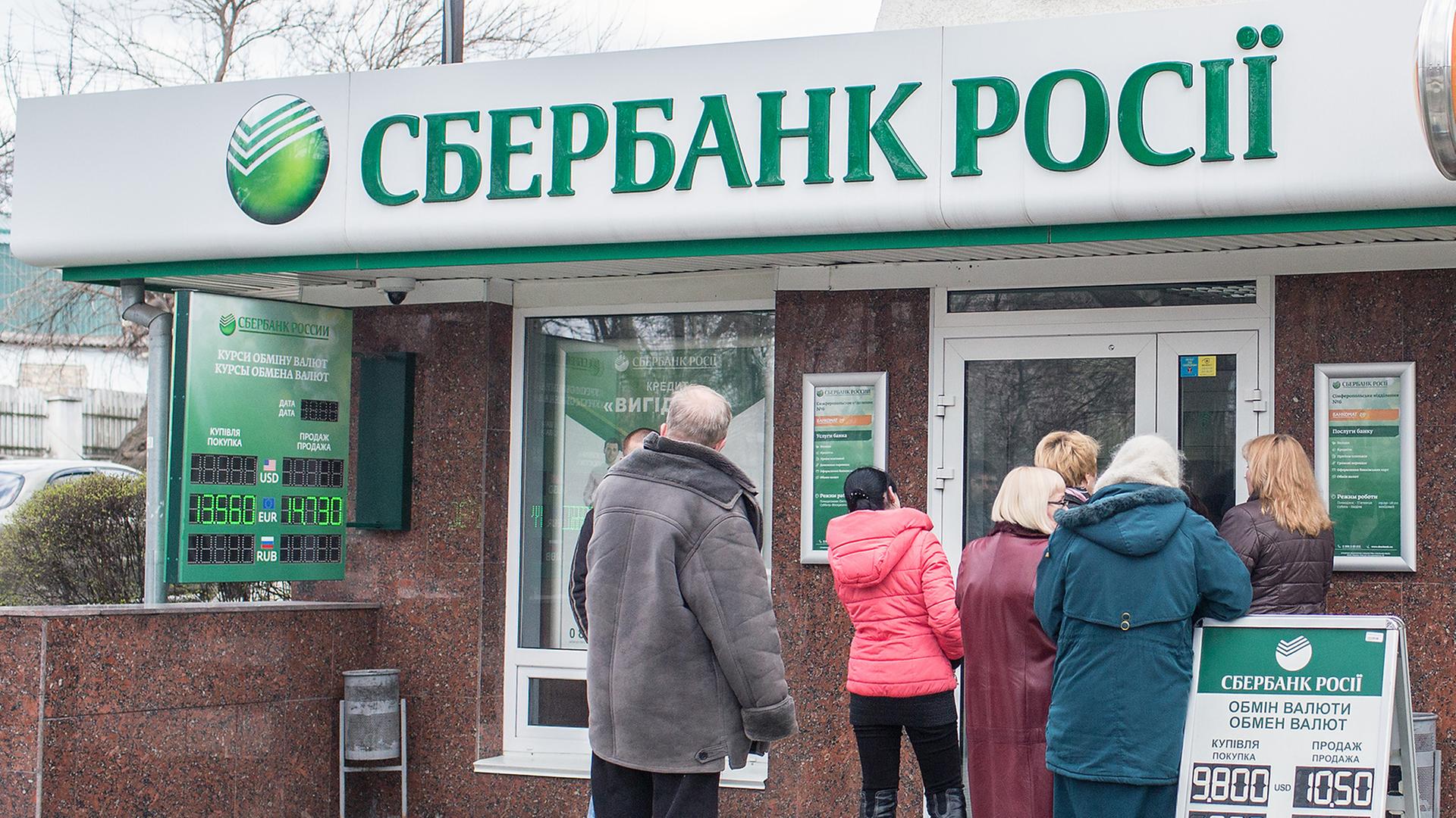 Menschen stehen am 18.03.2014 in Simferopol (Ukraine) vor einer Filiale der russischen Bank Sberbank in einer Schlange um Geld abzuheben. Menschen stehen am 18.03.2014 in Simferopol (Ukraine) vor einer Filiale der russischen Bank Sberbank in einer Schlange um Geld abzuheben.