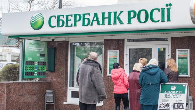 Menschen stehen am 18.03.2014 in Simferopol (Ukraine) vor einer Filiale der russischen Bank Sberbank in einer Schlange um Geld abzuheben.