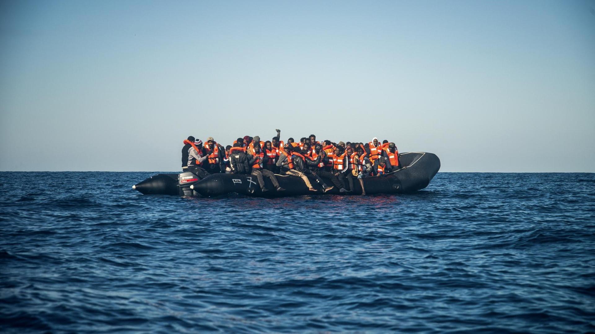 Ein Schlauchboot mit Geflüchteten treibt auf dem Mittelmeer. Ein Schlauchboot mit Geflüchteten treibt auf dem Mittelmeer.