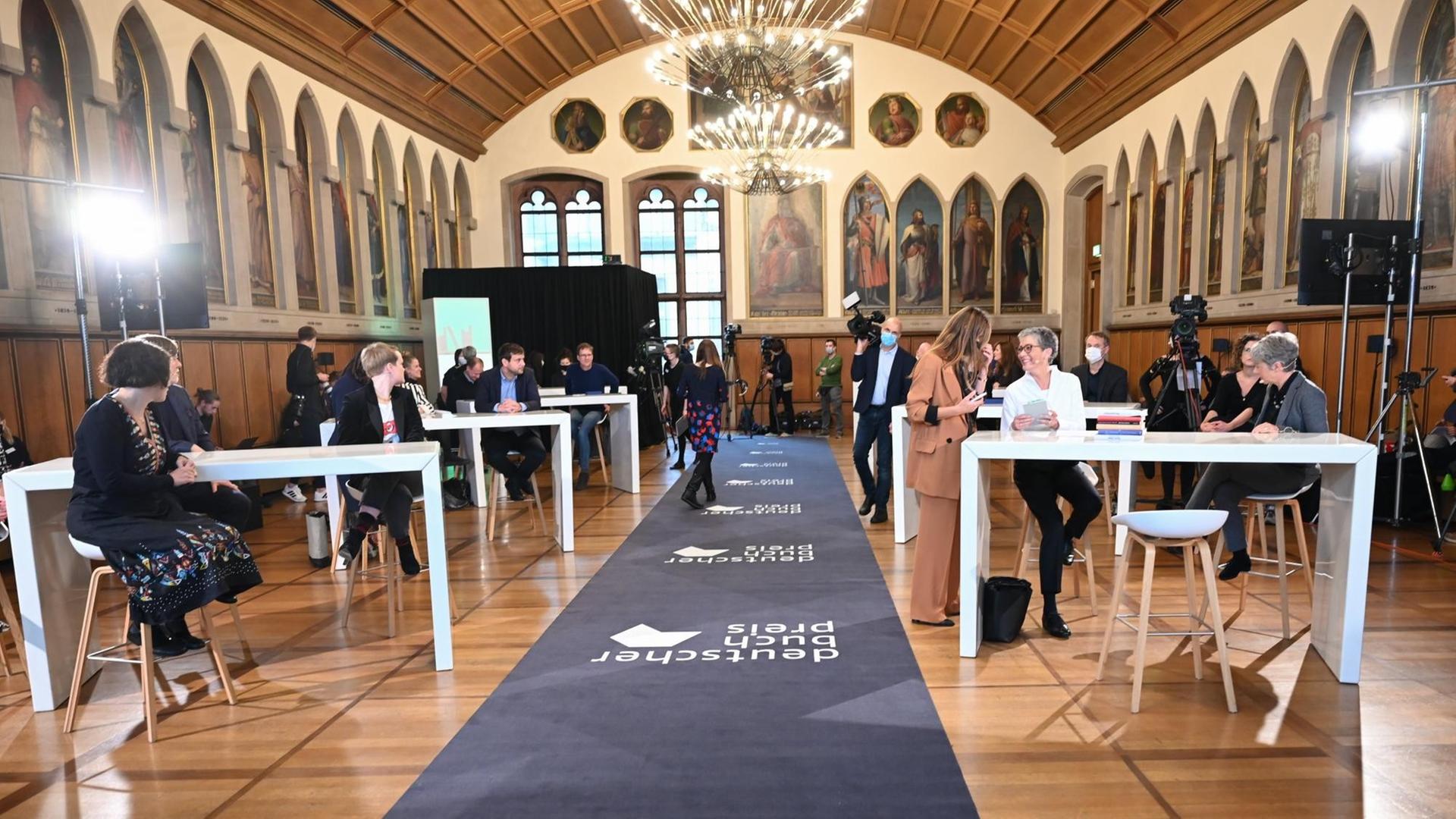 Der Kaisersaal des Frankfurter Römers während der Verleihung des Deutschen Buchpreises 2020: Nur wenige Gäste sitzen an großen weißen Tischen. Der Kaisersaal des Frankfurter Römers während der Verleihung des Deutschen Buchpreises 2020: Nur wenige Gäste sitzen an großen weißen Tischen.
