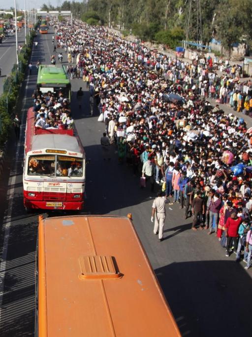 27.03.2020, Indien, Neu Delhi: Tausende Wanderarbeiter und Tagelöhner warten auf Busse, die sie von der Hauptstadt aus in ihre Heimatdörfer bringen sollen.