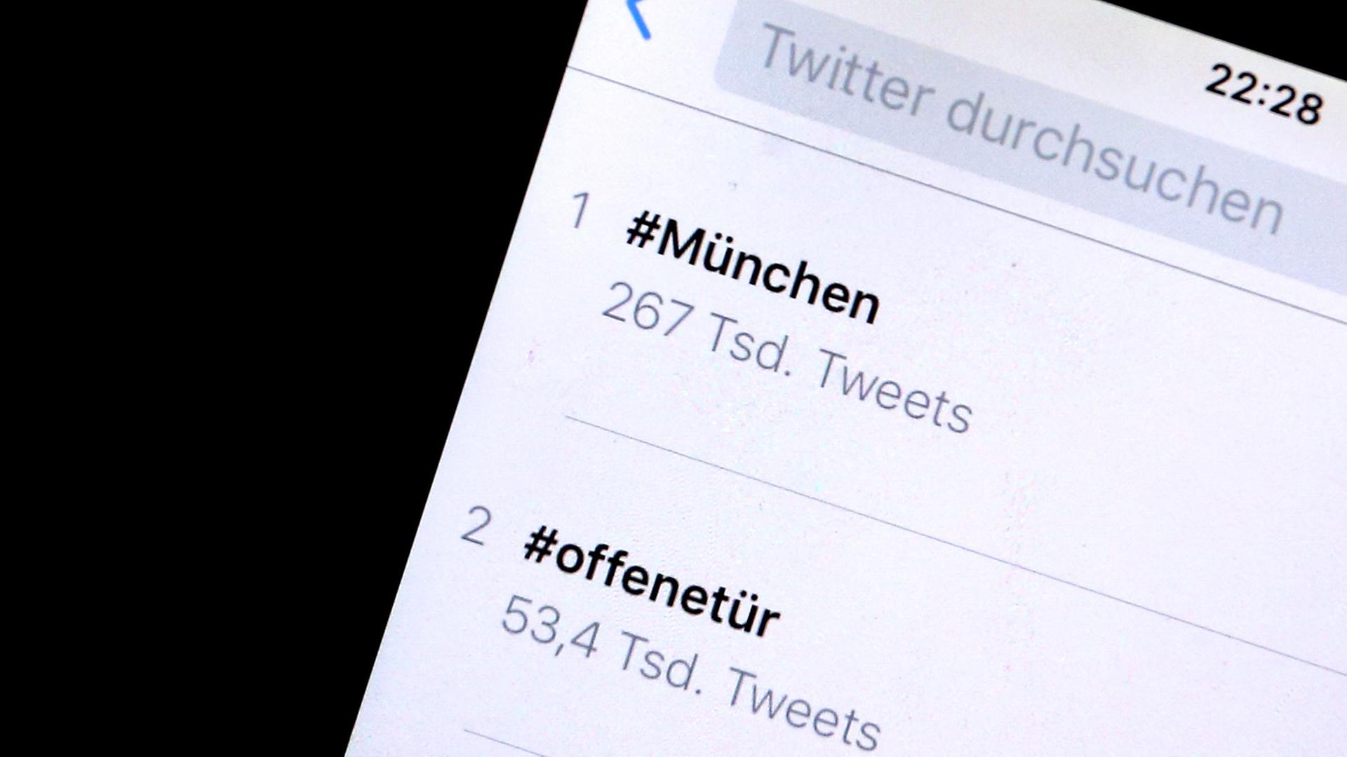 Auf einem iPhone sind Hashtags, die als Reaktion auf die Schießerei in München gepostet wurden, zu sehen. Über die Hashtags "#München" und "#offenetür" gewährten Bewohner der Stadt nach der Schießerei anderen Menschen Unterschlupf.