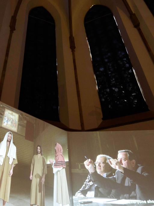 Besucher betrachten am 21.04.2015 bei der Medienkunstausstellung European Media Art Festival (EMAF) in der Kunsthalle der Dominikanerkirche in Osnabrück (Niedersachsen) die Videoinstallation Casting Jesus von Christian Jamkowski. Vom 22.04 bis 25.05.2015 sind in der Kunsthalle Filme, Skulturen und Performances zum Thema Medienkultur zu sehen.Ausstellung zeigt "Ironie in der Medienkunst"