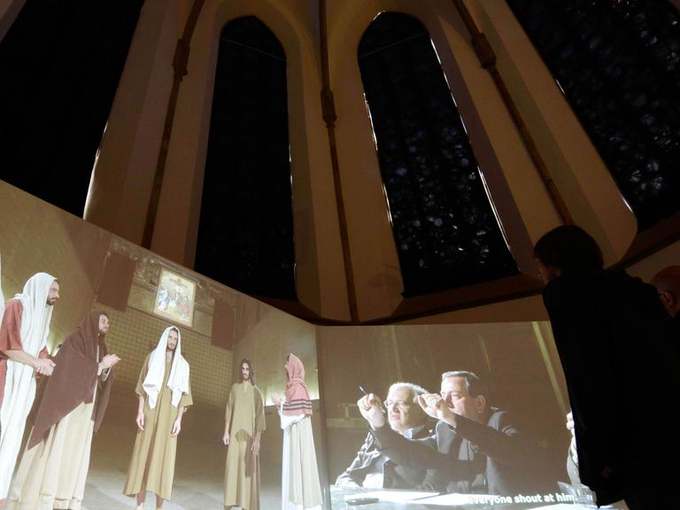 Besucher betrachten am 21.04.2015 bei der Medienkunstausstellung European Media Art Festival (EMAF) in der Kunsthalle der Dominikanerkirche in Osnabrück (Niedersachsen) die Videoinstallation Casting Jesus von Christian Jamkowski. Vom 22.04 bis 25.05.2015 sind in der Kunsthalle Filme, Skulturen und Performances zum Thema Medienkultur zu sehen.Ausstellung zeigt "Ironie in der Medienkunst"