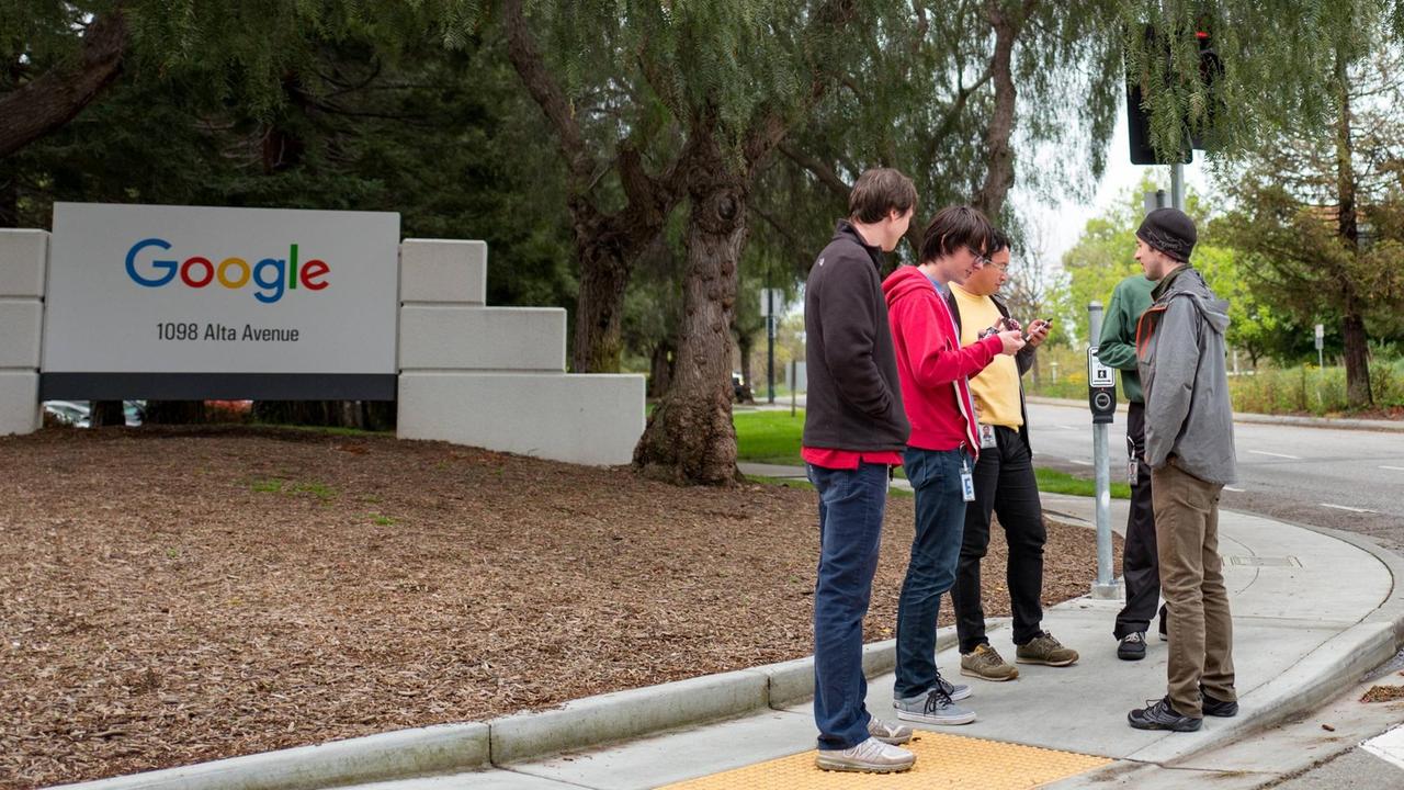 Eine Gruppe jugendlicher Mitarbeiter stehen vor dem Eingang von Google im Silicon Valley Eine Gruppe jugendlicher Mitarbeiter stehen vor dem Eingang von Google im Silicon Valley