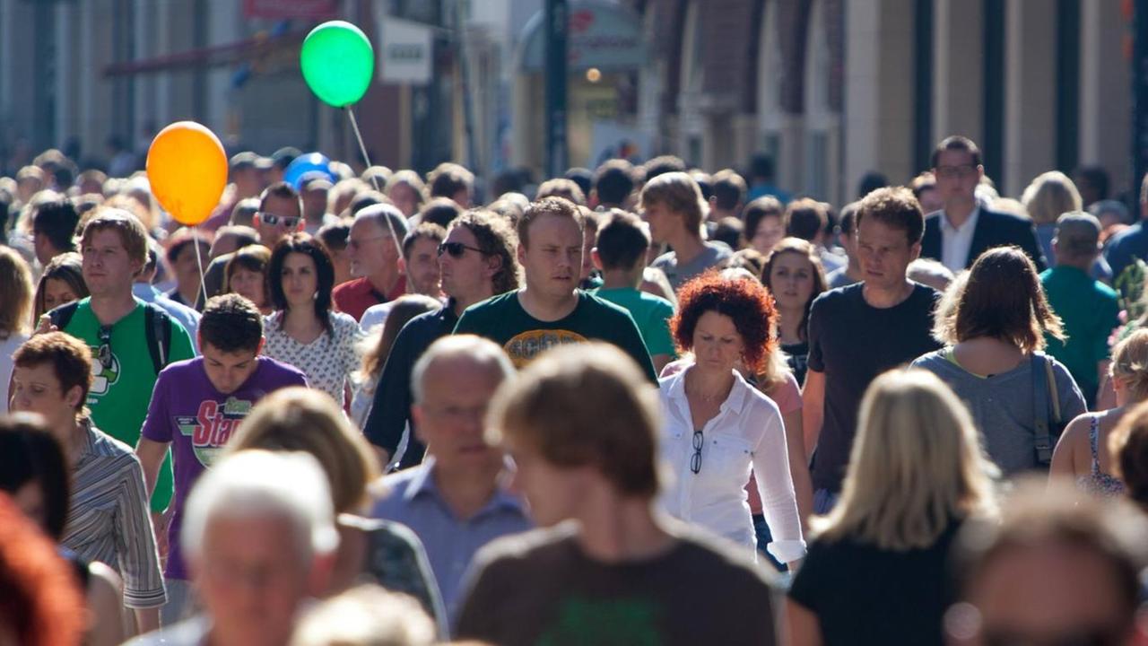 Eine Fußgängerzone mit vielen Menschen bei Sonnenschein. Eine Fußgängerzone mit vielen Menschen bei Sonnenschein.