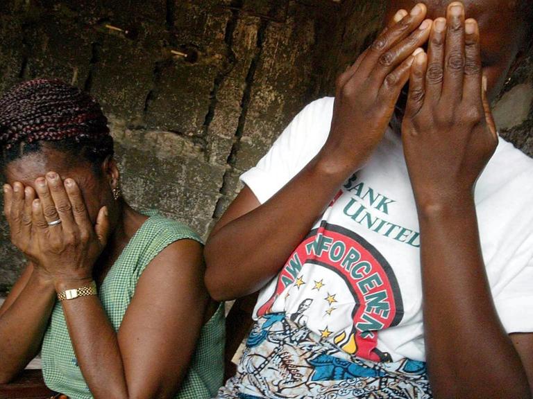Zwei Frauen halten sich die Hände vor das Gesicht. Sie wurden 2002 im Bügerkrieg in Liberia Opfer von sexueller Gewalt.