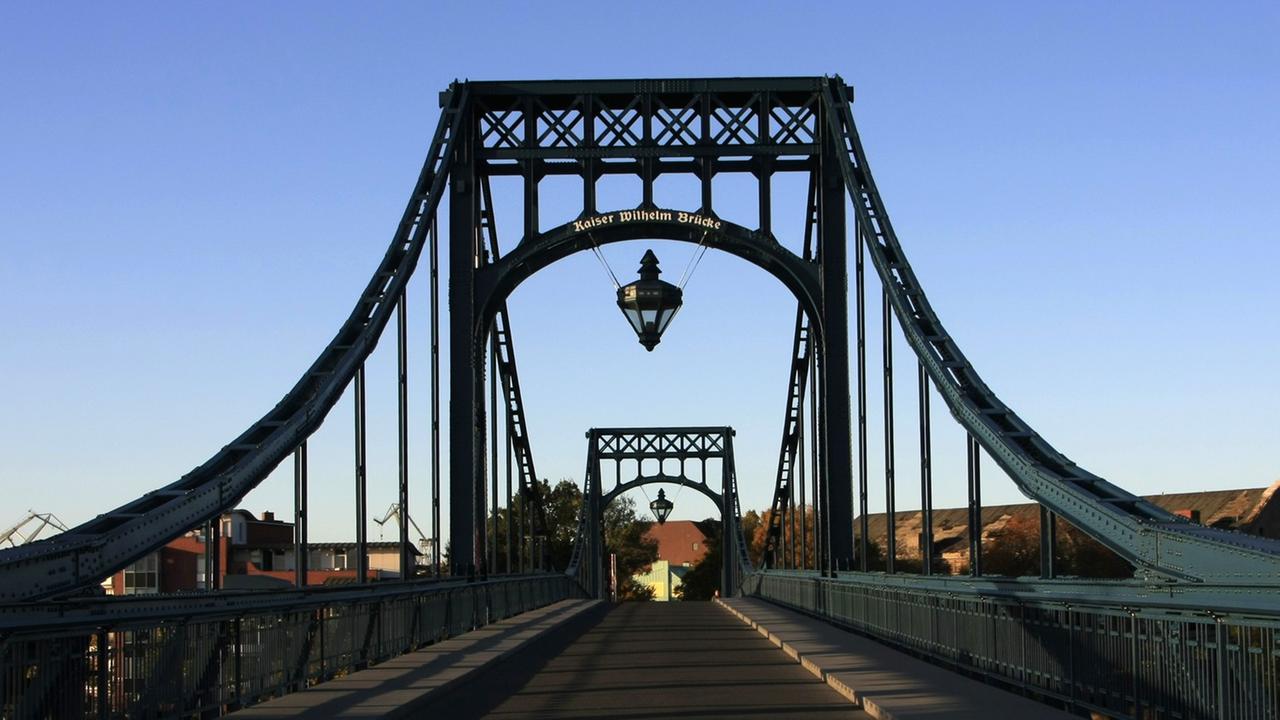 Die 159 Meter lange Kaiser-Wilhelm-Brücke in Wilhelmshaven wurde Anfang des letzten Jahrhunderts zwischen 1905 und 1907 als größte Drehbrücke Deutschlands erbaut. Sie ist das Wahrzeichen der Stadt Wilhelmshaven. Die 159 Meter lange Kaiser-Wilhelm-Brücke in Wilhelmshaven wurde Anfang des letzten Jahrhunderts zwischen 1905 und 1907 als größte Drehbrücke Deutschlands erbaut. Sie ist das Wahrzeichen der Stadt Wilhelmshaven.