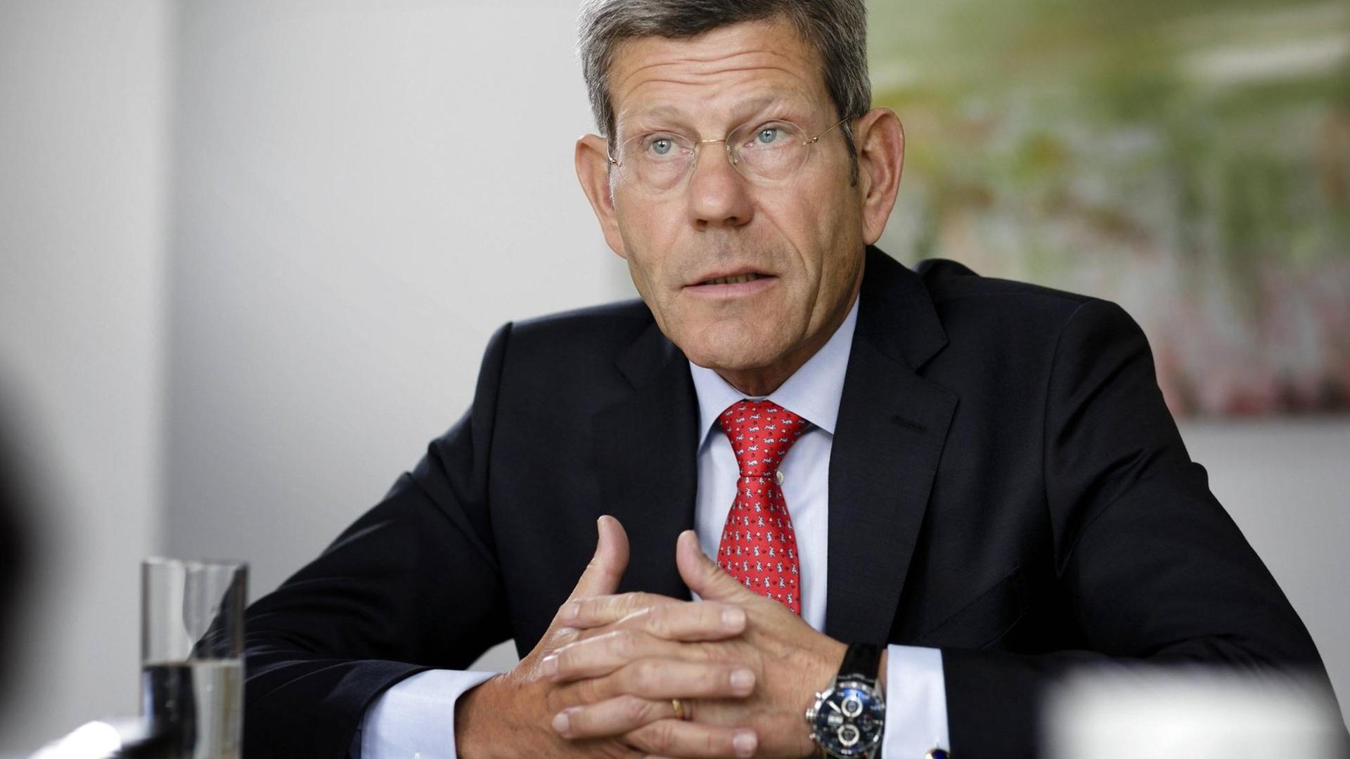 Bernhard Mattes sitzt an einem Tisch und spricht. Seine Hände sind ineinander verschränkt. Bernhard Mattes sitzt an einem Tisch und spricht. Seine Hände sind ineinander verschränkt.