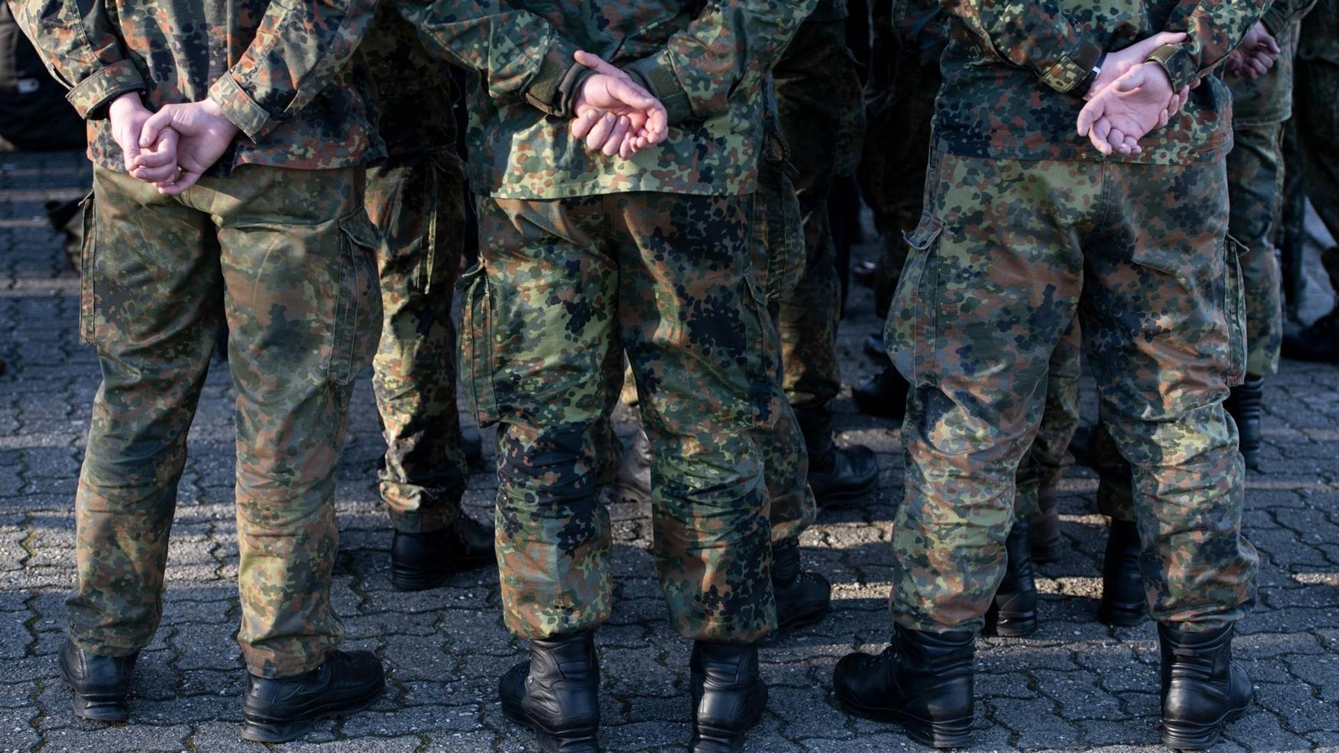 Mehrere Soldaten der Bundeswehr in Uniform von hinten mit den Händen auf dem Rücken Mehrere Soldaten der Bundeswehr in Uniform von hinten mit den Händen auf dem Rücken