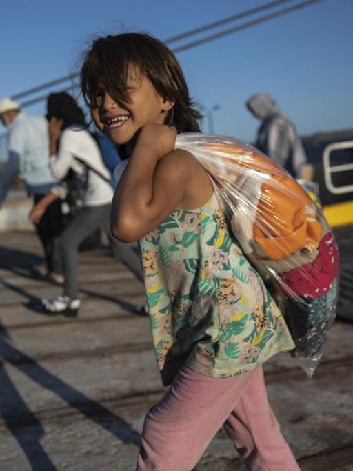 Ein afghanisches Kind verlässt ein Schiff im Hafen von Lavrio, Griechenland. Einige Menschen durften die Lager auf Lesbos verlassen.