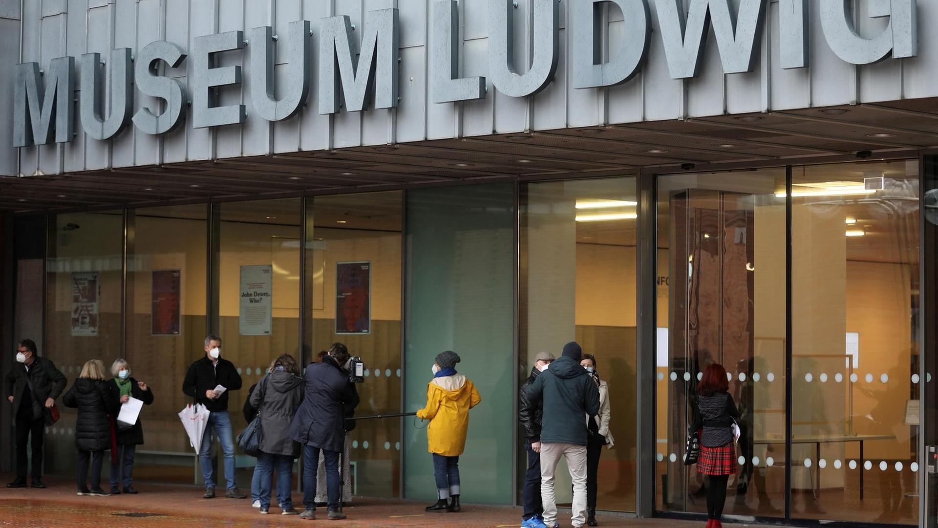 Besucherinnen und Besucher warten vor dem Museum Ludwig in Köln. Besucherinnen und Besucher warten vor dem Museum Ludwig in Köln.
