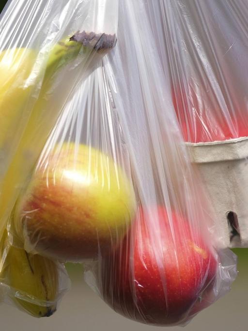 Verschiedenes Obst (Bananen, Äpfel, Erdbeeren) in dünnen Plastiktüten aus dem Supermarkt. Laut Bundesumweltministerium nutzten die Verbraucher 2018 im Schnitt pro Kopf 37 dieser sogenannten Hemdchenbeutel, nur zwei weniger als 2017 mit einem Pro-Kopf-Verbrauch von 39 Tueten. Im vergangenen Jahr seien in Deutschland etwas mehr als drei Milliarden der kleinen Beutel verbraucht worden.