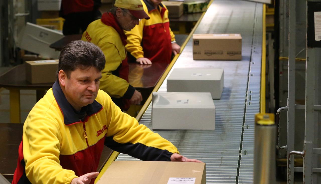 Mitarbeiter im Paketzentrum Rostock sortieren Pakete. Mitarbeiter im Paketzentrum Rostock sortieren Pakete.
