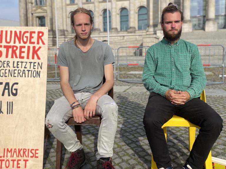 Simon Helmstedt und Jacob Heinze vor einem Schild, auf dem sie die Tage ihres Hungerstreiks zählen.