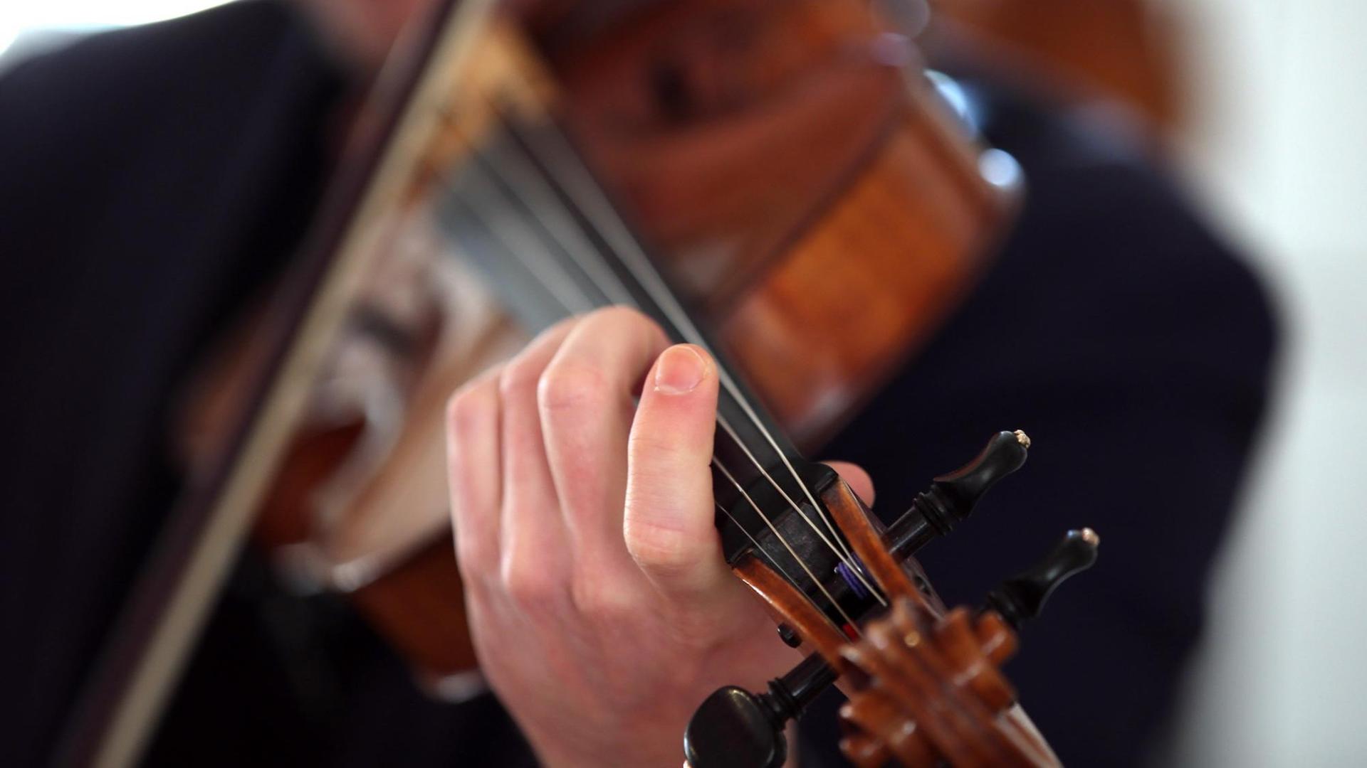 Ein Mann spielt auf einer Bratsche / Viola Ein Mann spielt auf einer Bratsche / Viola