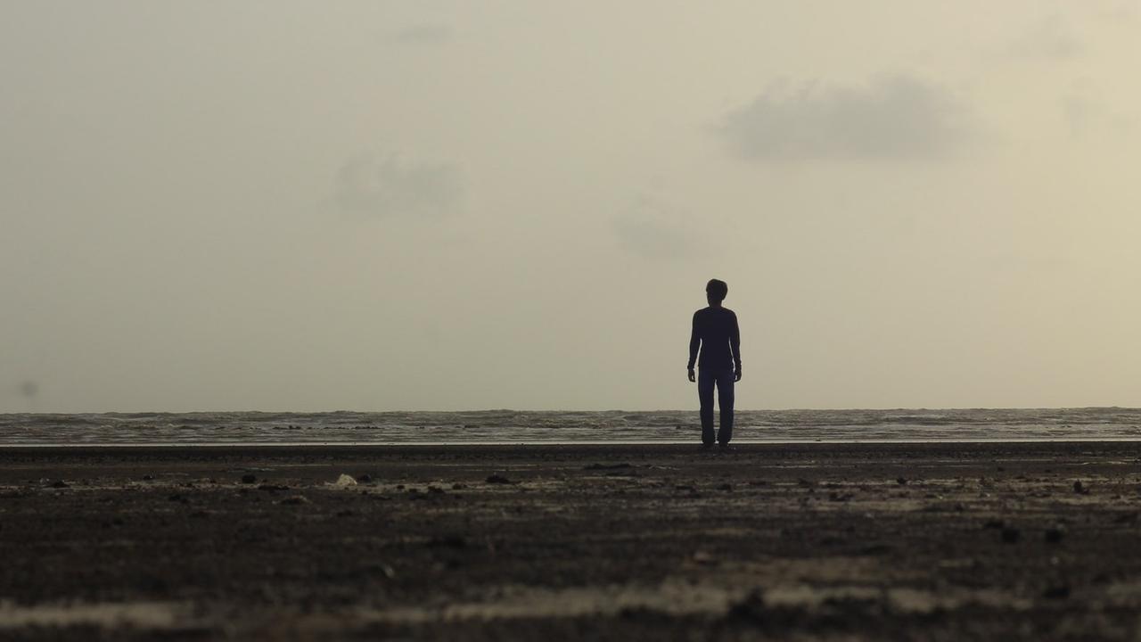 Eine Silhouette am Strand vor dem Meer. Eine Silhouette am Strand vor dem Meer.