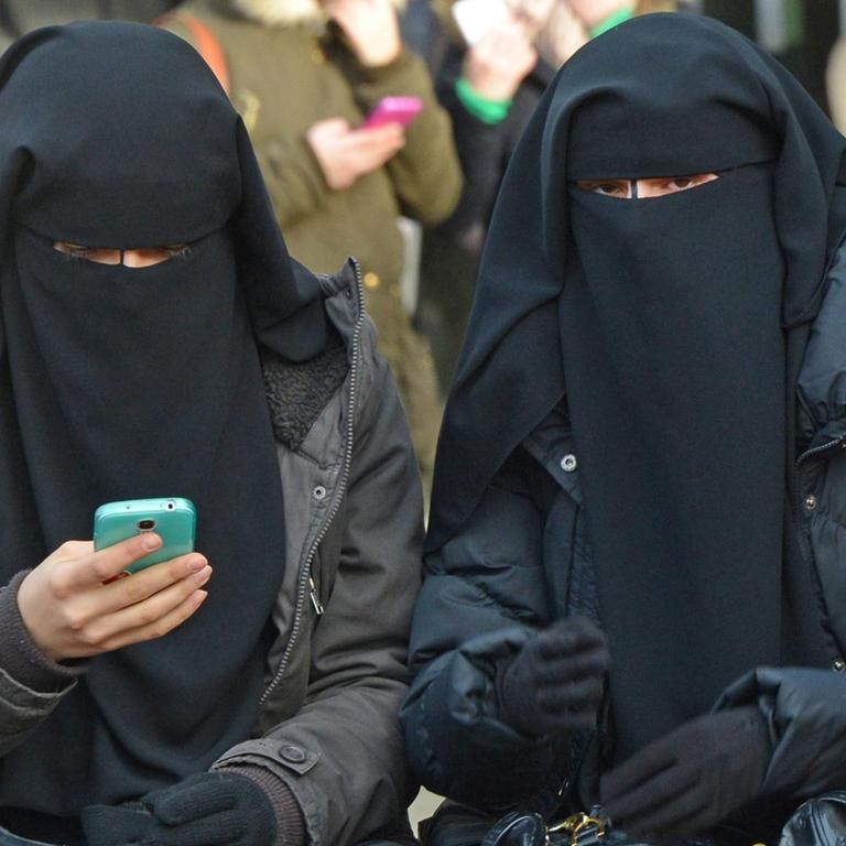 Verschleierte Frauen auf einer Kundgebung des Salafistenpredigers Pierre Vogel in Pforzheim. Eine von ihnen benutzt ein Smartphone.